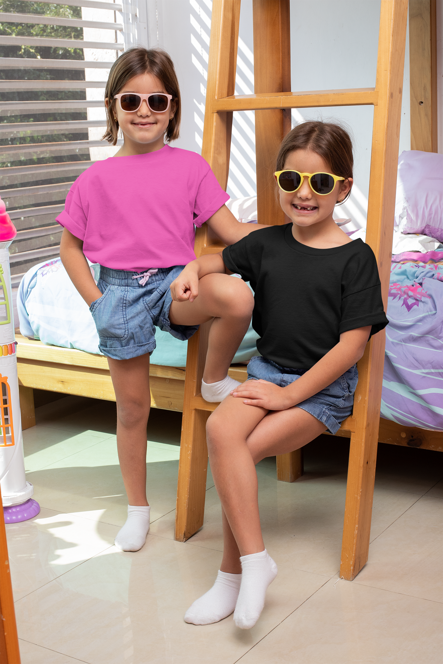 Two girls wearing Qikink girls crew neck t-shirt in pink and black paired with denim shorts
